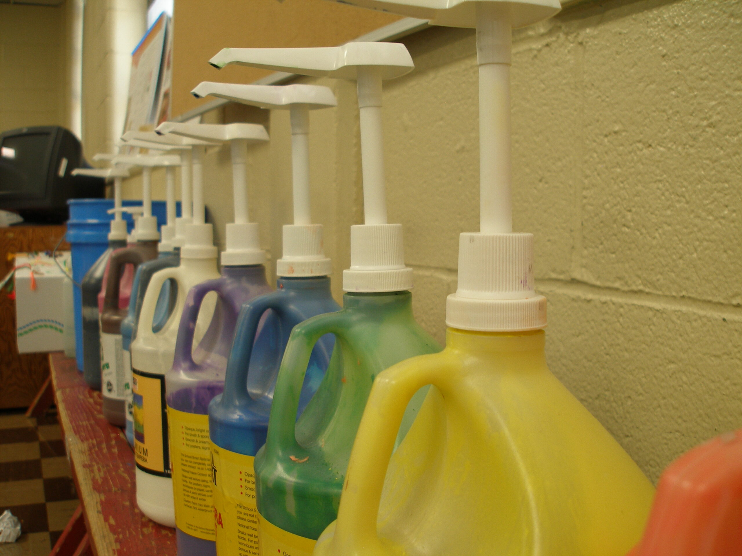 Fotografía de botellas de pintura alineadas y con bombas de distribución para los estudiantes.